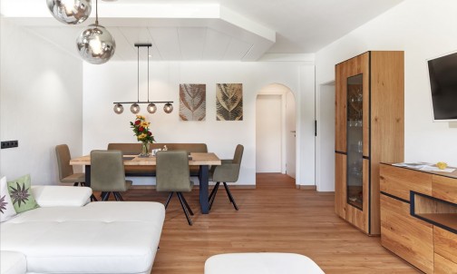 Geräumiges Wohnzimmer mit Esstisch, Couch und Flat-TV